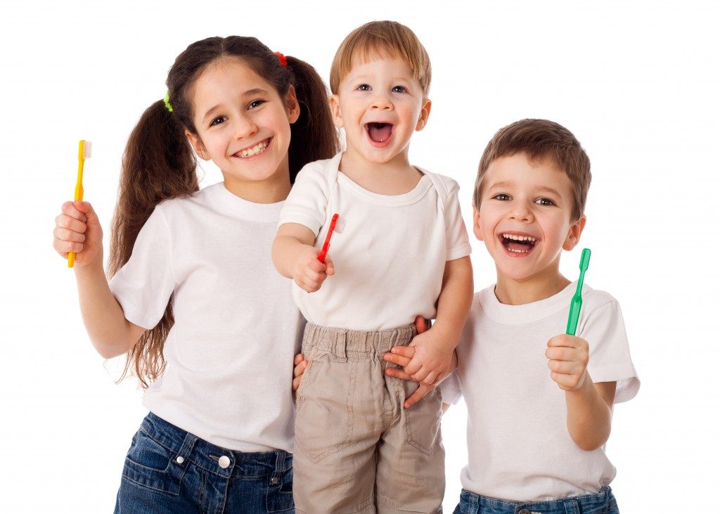 Kids smiling while holding a toothbrush