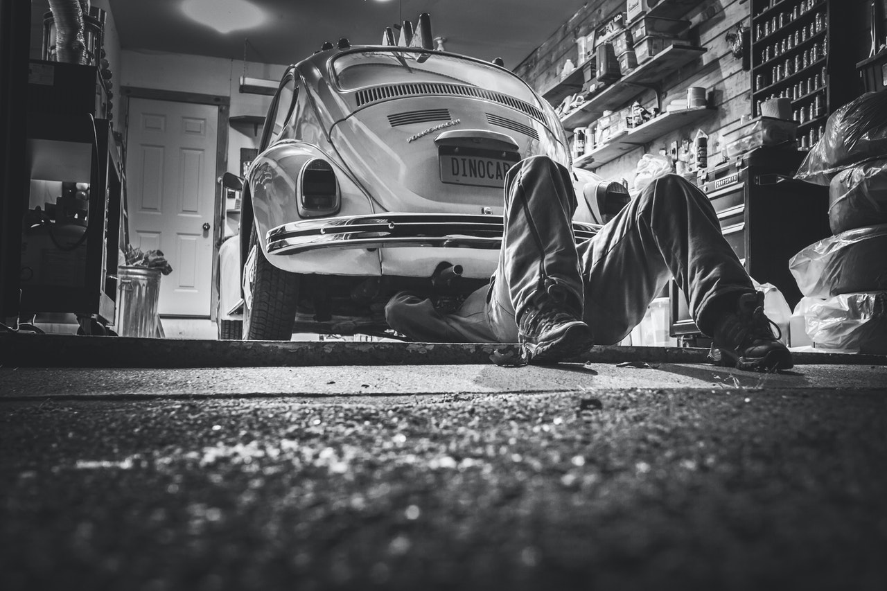 man fixing car in garage