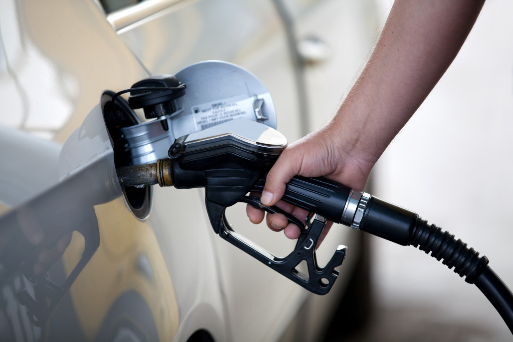 Close up of a hand filling gas in silver color car