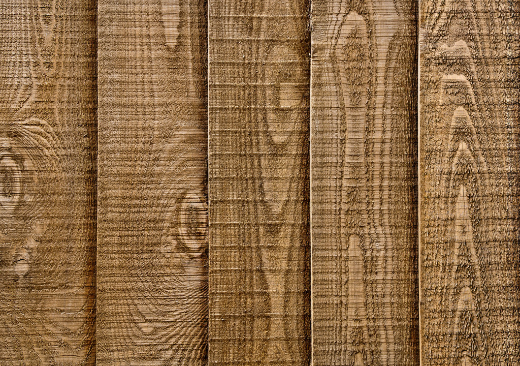 A close up section of wooden garden fencing with vertic