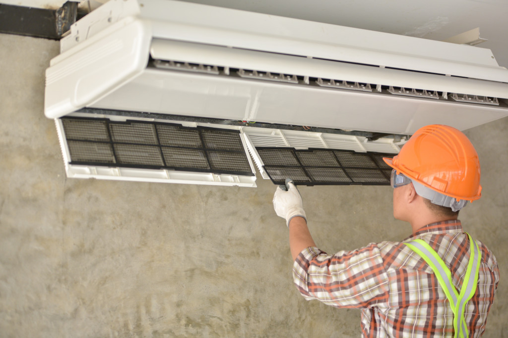 An expert cleaning an air conditioning unit at home