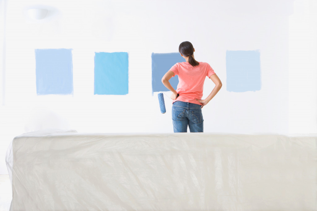 woman holding paint roller choosing a shade of blue