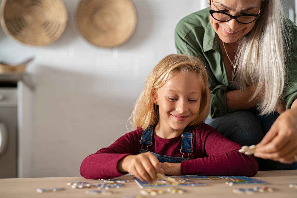 mom teaching daughter to do puzzles